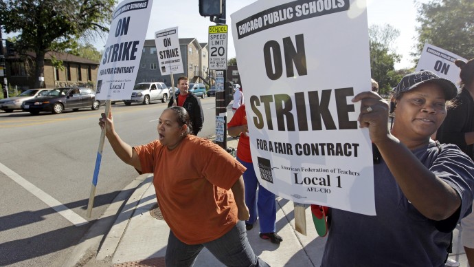 Parents of Chicago public school students, Carmen Brownlee, left, and, Latonya Williams, right, walk a picket line outside Shoop Elementary School in support of striking CPS teachers, Tuesday, Sept. 11, 2012. (AP Photo/M. Spencer Green)