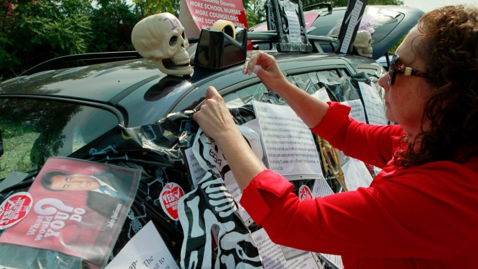 Philomena Johnson, a delegate from Little Village Academy, decorates her vehicle to highlight the need for increased social services in schools before attending a meeting of the Chicago Teachers Union delegates Sunday, Sept. 16, 2012 in Chicago. (AP Photo/Sitthixay Ditthavong)