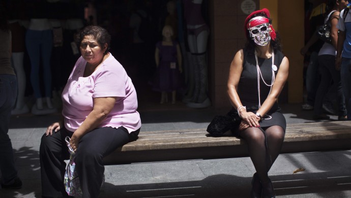 Human rights activist Brenda Hernandez, right, wears a mask saying she's portraying Zury Rios Sosa, daughter of former dictator Efrain Rios Montt, in Guatemala City, Saturday, Sept. 8, 2012. (AP Photo/Rodrigo Abd)