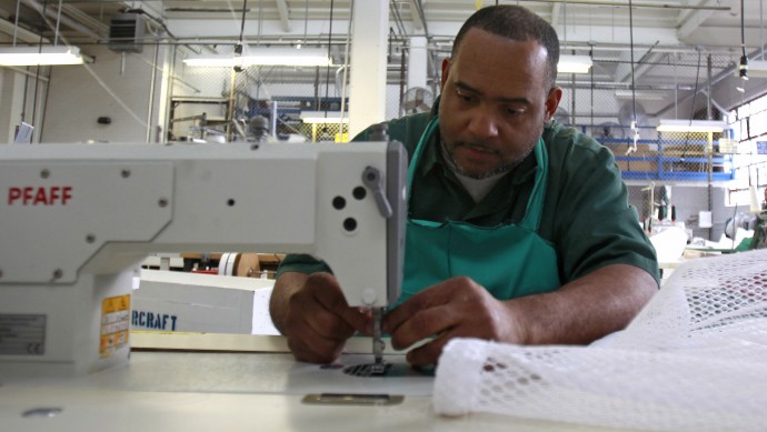 In this Feb. 1, 2012 photo, inmate William Adams, of Hazlehurst, Ga., sews while working in a garment shop at Coxsackie Correctional Facility in Coxsackie, N.Y. (AP Photo/Mike Groll)