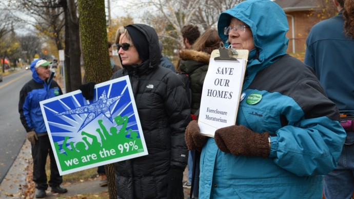 Activists in Minneapolis stand in the cold at an anti-foreclosure rally Thursday evening, waving signs and showing support for a local family facing eviction. (Photo by Trisha Marczak/MintPress)