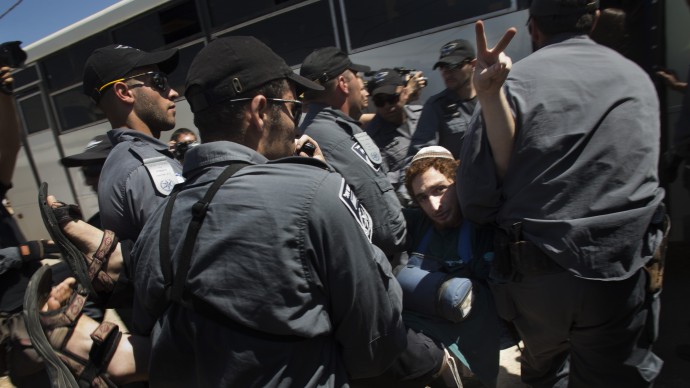 A Jewish settler flashes the victory sign while being evacuated by Israeli police forces from a house in the unauthorized West Bank Jewish settlement of Migron, Sunday, Sept. 2, 2012. Israel completed evacuation of Migron, culminating years of legal wrangling in a case that has become a rallying cry for hardline settler groups opposed to any withdrawal from occupied land claimed by the Palestinians. (AP Photo/Bernat Armangue)