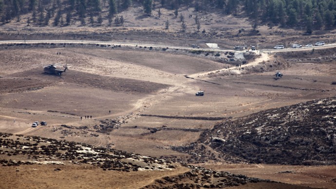 Israeli Army vehicles and helicopters are seen in an open area as they search for the remains of a drone in the Negev southern Israel, Saturday, Oct. 6, 2012. (AP Photo/Yehuda Lachiani)