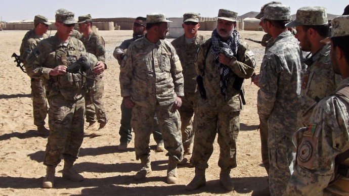 This photo taken Oct. 10, 2012 shows Army Brig. Gen. John Charlton, left, foreground, talking to members of the Afghan National Civil Order Police at a military base in Ghazni Province, Afghanistan. (AP Photo/Robert Burns)