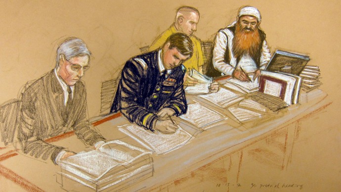 In this photo of a sketch by courtroom artist Janet Hamlin and reviewed by the U.S. Department of Defense, Khalid Sheikh Mohammed, far right, writes on a paper as he sits at the defense table with his legal team, Army Capt. Jason Wright, second from left, lawyer David Nevin, left, and a court translator during the Military Commissions pretrial hearing in the Guantanamo Bay U.S. Naval Base in Cuba, Monday, Oct. 15, 2012. (AP Photo/Janet Hamlin, Pool)