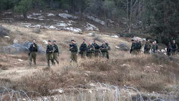 Israeli soldiers are seen after searching for the remains of a drone in the Negev southern Israel, Saturday, Oct. 6, 2012. (AP Photo/Tsafrir Abayov)