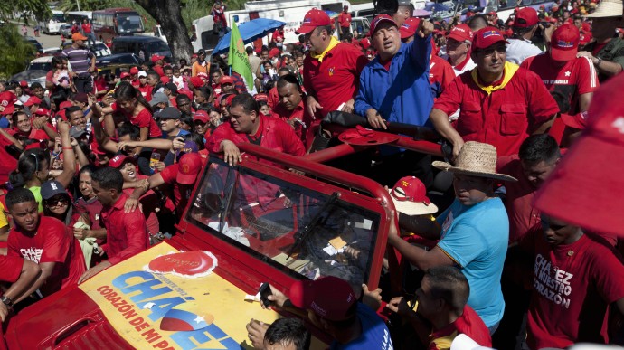 Venezuela's President Hugo Chavez greets supporters from the top of a vehicle during a campaign caravan from Barinas to Caracas, in Sabaneta, Venezuela, Monday, Oct. 1, 2012. (AP Photo/Rodrigo Abd)