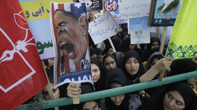 Iranian girls, one of them holding up a caricature of President Barack Obama while others hold pro-government posters, attend an annual state-backed rally in front of the former U.S. Embassy in Tehran, Iran, Friday, Nov. 2, 2012. (AP Photo/Vahid Salemi)