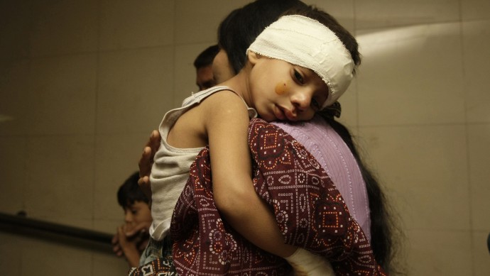 A Pakistani mother holds her injured child at a local hospital in Karachi, Pakistan  on Wednesday, Nov. 21, 2012. (AP Photo/Fareed Khan)