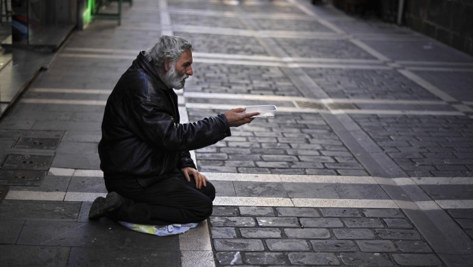 A man begs for alms in a street, in Pamplona, northern Spain, Tuesday, Oct. 30, 2012. (AP Photo/Alvaro Barrientos)