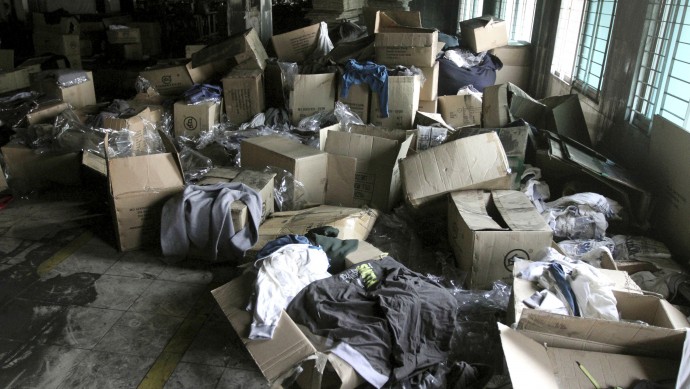 Boxes of garments lie near equipment charred in the fire that killed 112 workers Saturday at the Tazreen Fashions Ltd. factory, a garment factory on the outskirts of Dhaha, Bangladesh, Wednesday, Nov. 28, 2012. (AP Photo/Ashraful Alam Tito)