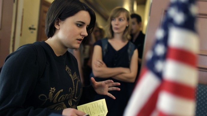 College student Paige McLoughlin, 19, of Parker, Colo., talks over paperwork with an electoral official before voting in the general election, at a polling station serving the local student population on the campus of the University of Colorado, in Boulder, Colo., Tuesday, Nov. 6, 2012. (AP Photo/Brennan Linsley)