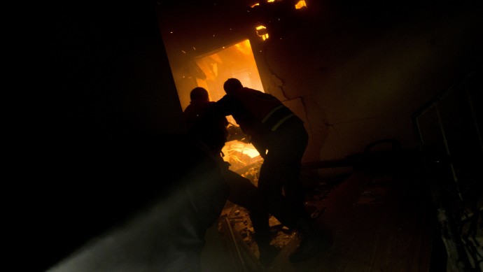Palestinians firefighters try to extinguish a fire after an Israeli strike on a building of Gaza City, Monday, Nov. 19, 2012. (AP Photo/Bernat Armangue)