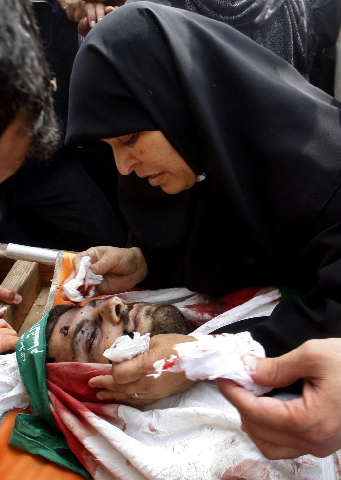 The mother of Palestinian Hamas militant Loay Abu Jarad grieves over his body during his funeral in Beit Lahia, northern Gaza Strip, Wednesday, Oct. 24, 2012. (AP Photo/Hatem Moussa)