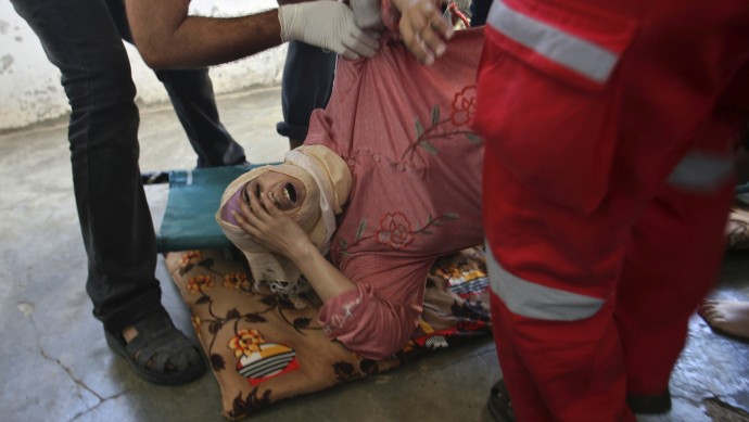 Palestinian medics help a wounded woman at her family house following an Israeli air strike in Khan Younis southern Gaza Strip, Thursday, Nov. 15, 2012. (AP Photo/Eyad Baba)
