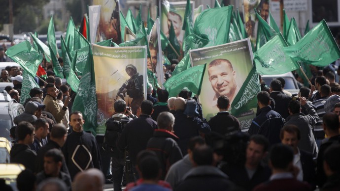 Palestinian Hamas supporters carry obituary posters of Hamas' Ahmed Jabari and Hamas flags as they march in support of the people of the Gaza Strip and against Israel's military operations, in the West Bank city of Ramallah, Friday, Nov. 16, 2012. (AP Photo/Majdi Mohammed)