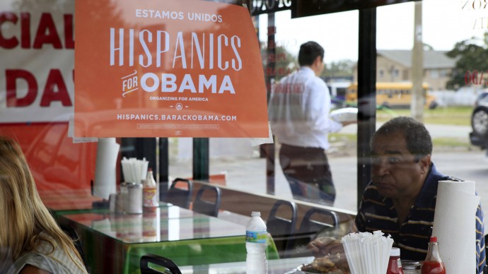 In this Oct. 26, 2012, file photo, Spanish language election campaign signs promoting President Barack Obama hang on the windows at Lechonera El Barrio Restaurant in Orlando, Fla. (AP Photo/Julie Fletcher)