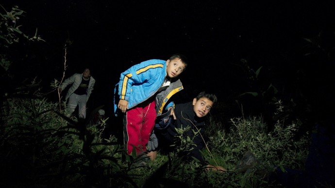 Two boys pretend to be migrants crossing the U.S. border. (AP Photo/Gregory Bull)
