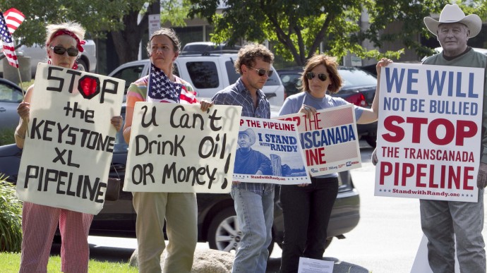Protestors opposed to the Keystone XL pipeline hold signs outside the office of Rep. Lee Terry, R-Neb., in Omaha, Neb., Tuesday, July 26, 2011. (AP Photo/Nati Harnik)