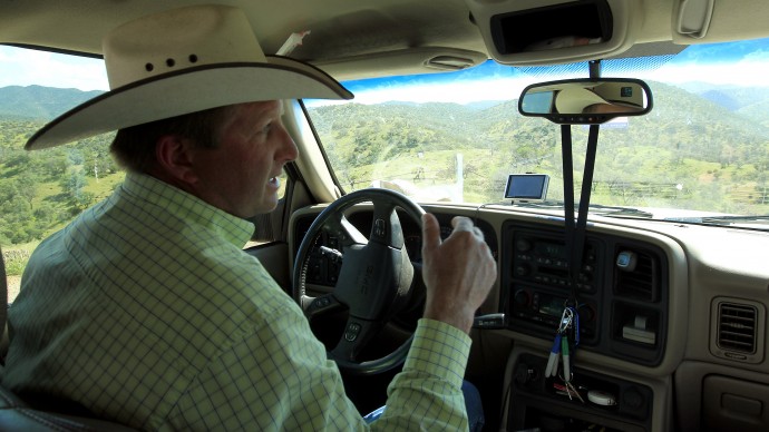 In this Friday, Aug. 10, 2012 photo, rancher Dan Bell, who leases a 35,000-acre cattle ranch along the border between the United States and Mexico, drives around as he checks out part of the property, in Nogales, Ariz. (AP Photo/Ross D. Franklin)
