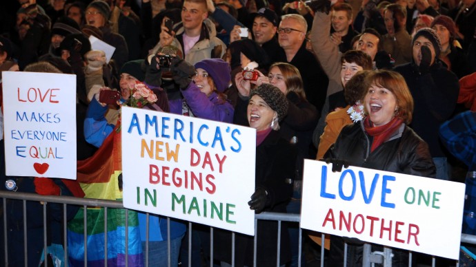 A crowd cheers at 12:30 a.m. Saturday, Dec. 29, 2012, as the first same-sex couple to be legally married in Maine departs City Hall in Portland, Maine. (AP Photo/Robert F. Bukaty)