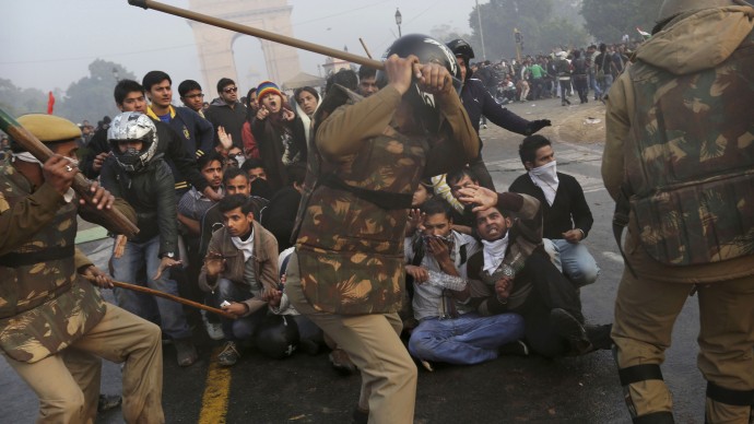 Protesters shield themselves as Indian police beat them with sticks during a violent demonstration near the India Gate against a gang rape and brutal beating of a 23-year-old student on a bus last week, in New Delhi, India, Sunday, Dec. 23, 2012. (AP Photo/Kevin Frayer)
