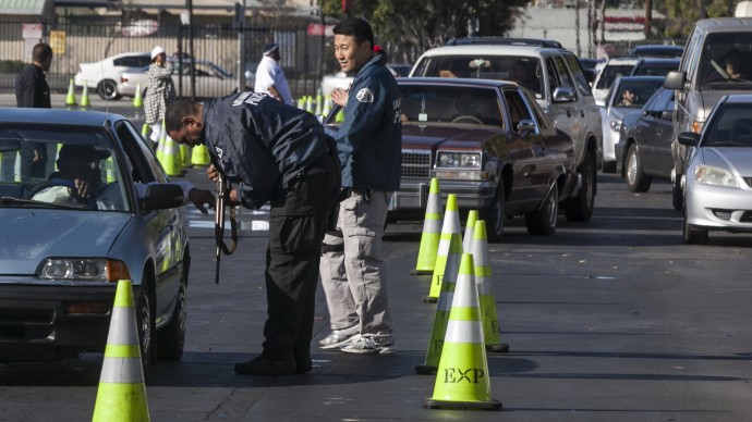 Motorists wait inside their cars to drop guns to waiting Los Angeles Police officials at the LA Memorial Sports Arena in Los Angeles Wednesday, Dec. 26, 2012. (AP Photo/Damian Dovarganes)