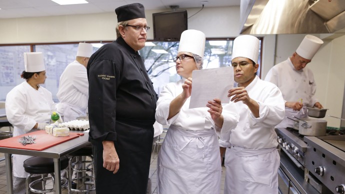 Chief instructor Larry Baumann, left, answers questions for students in a professional cook class at the Culinary Academy of Las Vegas, Friday, Dec. 14, 2012, in Las Vegas.(AP Photo/Julie Jacobson)