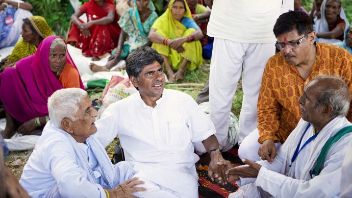 Rajagopal PV (center) surrounded by Satyagrahis, after reaching the place to eat and spend the night. (Photo Ekta Parishad)