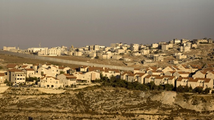 In this July 29, 2009 file photo, the Jewish neighborhood of Pisgat Zeev in east Jerusalem is seen with the Shuafat refugee camp, background, and Israel's separation barrier running between them. (AP Photo/Sebastian Scheiner, File)