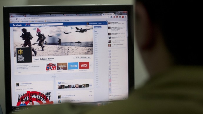 An Israeli soldier poses as he looks at the Facebook page of the IDF, at the IDF spokesperson office in Jerusalem, Thursday, Nov. 15, 2012. (AP Photo/Sebastian Scheiner)
