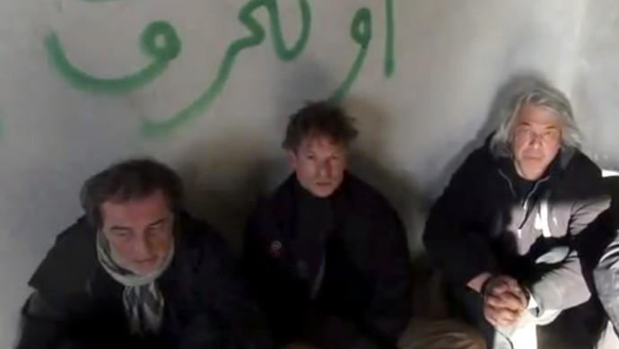 This image taken from undated amateur video posted on the Internet shows NBC chief foreign correspondent Richard Engel, center, with NBC Turkey reporter Aziz Akyavas, left, and NBC photographer John Kooistra, right, after they were taken hostage in Syria. (AP Photo/Amateur Video)