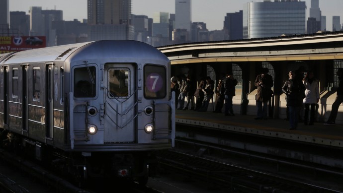 Commuters wait on the platform as a train passes through the 40th St-Lowry St Station, where a man was killed after being pushed onto the subway tracks, in the Queens section of New York, Friday, Dec. 28, 2012. (AP Photo/Seth Wenig)