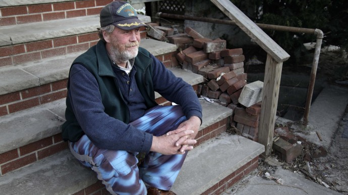 John Frawley sits on the porch of his house, which was damaged during Superstorm Sandy, on the Rockaway Peninsula in New York, Thursday, Nov. 29, 2012. (AP Photo/Seth Wenig)