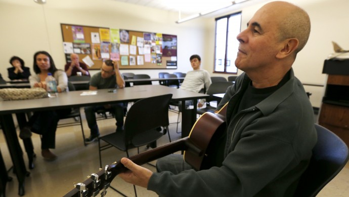 In this Oct. 10, 2012, photo, musician Julio Fernandez holds a guitar during a class session at Montclair State University in Montclair, N.J. (AP Photo/Julio Cortez)