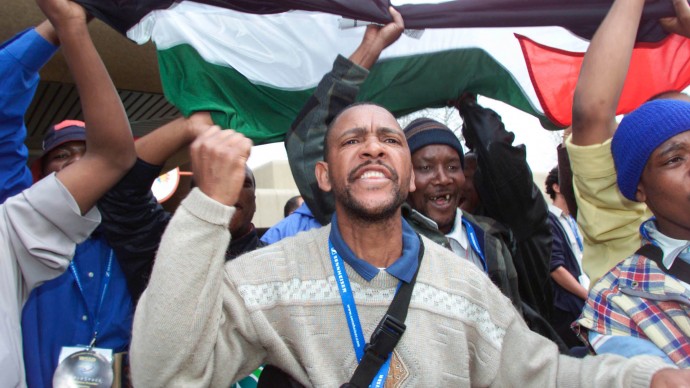 Friends of Palestine living in South Africa, chant anti-Israel slogans during a stand off between Palestinian supporters and Hebrew students from Israel at Nasrec Exposition Centre, Johannesburg, South Africa Tuesday, Aug. 27, 2002, during the World Summit on Sustainable Development nearby.  (AP Photo/Obed Zilwa)