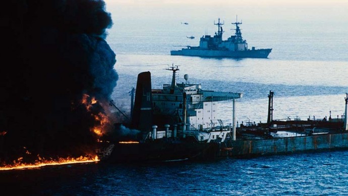 The USS Chandler comes to the aid of the Cypriot flagged oil tanker Pivot after it was attacked and set ablaze by an Iranian warship on Dec. 12, 1987. Both a news helicopter and a United States navy helicopter helped rescue the crew from the stricken ship. (Photo Norbert Schiller)