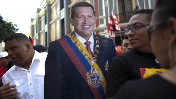 A life-size cut out image of Venezuela's President Hugo Chavez is carried by a Chavez supporter during a symbolic inauguration ceremony for Chavez in Caracas, Venezuela, Thursday, Jan. 10, 2013. (AP Photo/Ariana Cubillos)