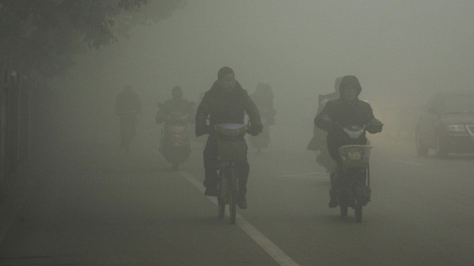 Cyclists travel on the road on a hazy day in Huaibei, in central China's Anhui province Monday Jan. 14, 2013. (AP Photo)