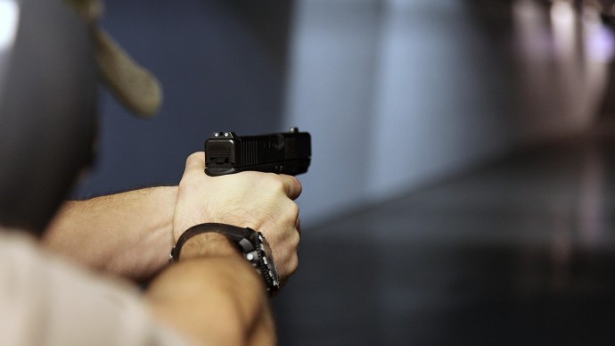 In this Jan. 4, 2013, photo, a man fires a hand gun at Sandy Springs Gun Club and Range, in Sandy Springs, Ga. (AP Photo/Robert Ray)