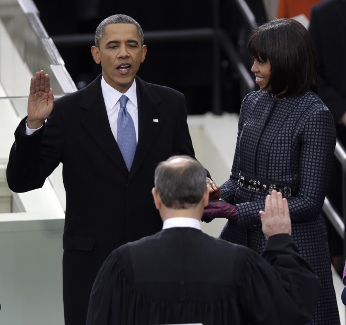 President Barack Obama receives the oath of office from Chief Justice John Roberts as first Lady Michelle holds the bible at the ceremonial swearing-in at the U.S. Capitol during the 57th Presidential Inauguration in Washington, Monday, Jan. 21, 2013. (AP Photo/Evan Vucci)