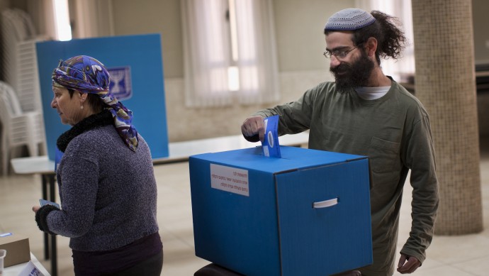 An Israeli Jewish settler casts his vote in the West Bank town of Hebron during legislative elections, Tuesday, Jan. 22, 2013. (AP Photo/Bernat Armangue)