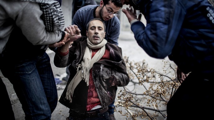 Men help a wounded civilian after a mortar attack in the Saif al-Dawlah neighborhood of Aleppo, Syria, Sunday, Jan. 13, 2013. (AP Photo/Andoni Lubaki)
