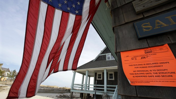 In this Jan. 3, 2013, file photo, an unsafe for human occupancy sticker is attached to a home that was severely damaged by Superstorm Sandy in Bay Head, N.J. (AP Photo/Mel Evans)
