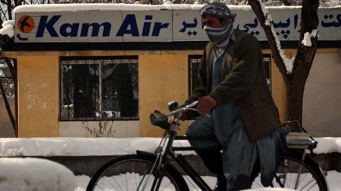 An Afghan man rides a bicycle as he pass by the Kam Air office in Kabul, Afghanistan on Friday Feb 4  2005.  (AP Photo/Emilio Morenatti)