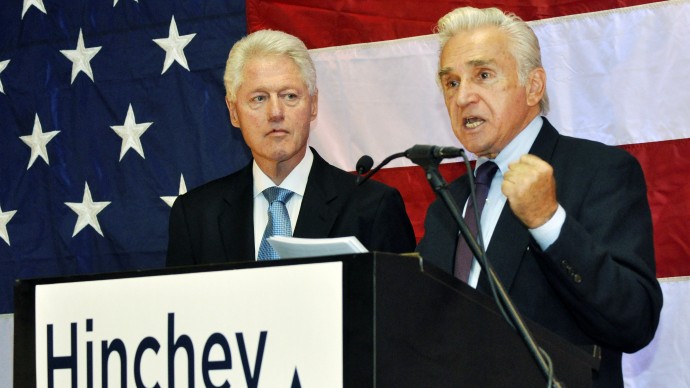 Former President Bill Clinton, left, listens as Congressman Maurice Hinchey (D-N.Y.) addresses the crowd at a rally in his honor in Binghamton, N.Y., Monday, October 11, 2010. (AP Photo/Heather Ainsworth)