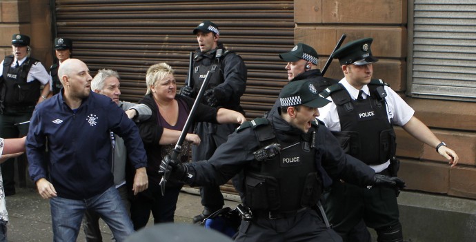 Police officers attempt to stop fighting between loyalist and Nationalist groups outside outside St Patrick's Roman Catholic Church in Belfast, Northern Ireland, Saturday, Aug. 25, 2012. (AP Photo/Peter Morrison)